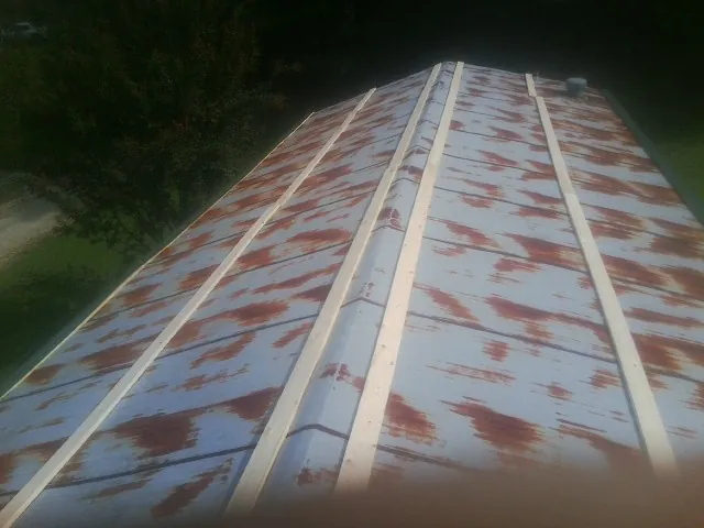 Rusted metal roof panels with new wood purlins before replacement — Storm Damage Roof Repair in Falkville by Roofing Brothers