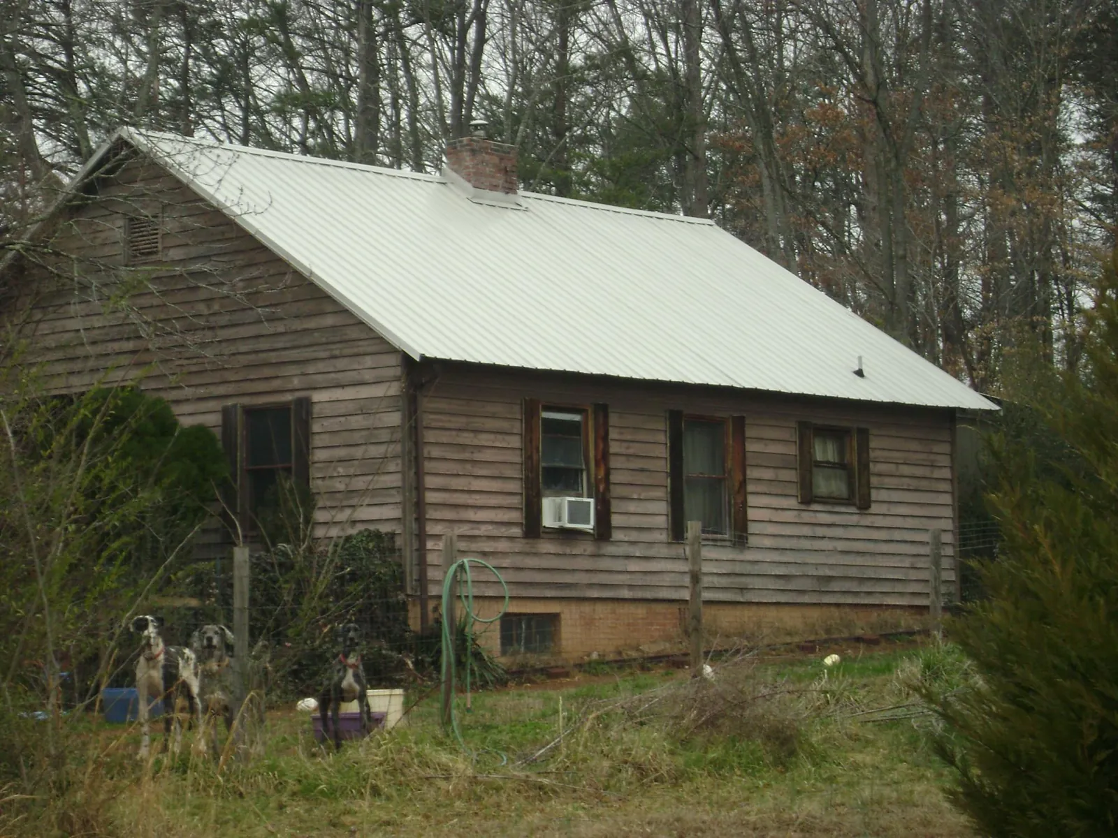White metal roof on an old wood sided farmhouse, from a Metal Roof Installation job in Falkville